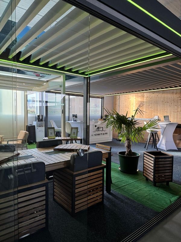 Modernes Interieur mit Holz- und Glaselementen. Mit eleganten Möbeln, einer Topfpalme und einem hohen Tisch, die eine stilvolle und einladende Atmosphäre schaffen.