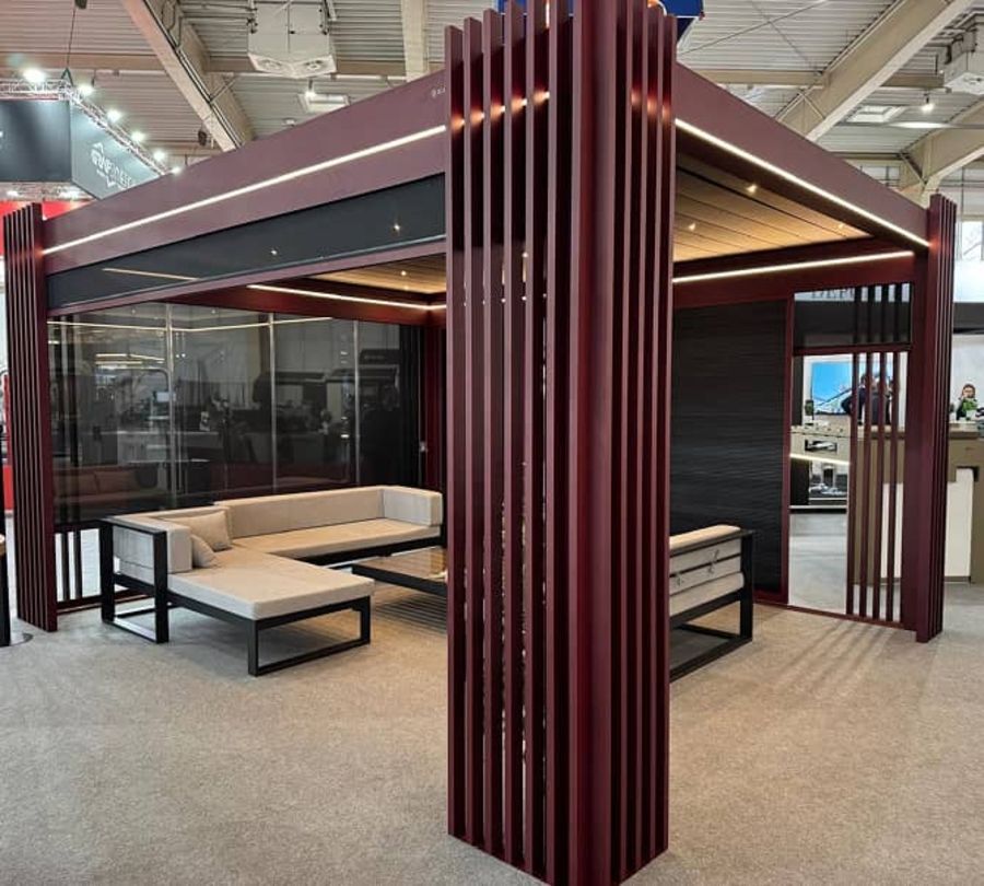 Individuell gefertigte Sitzlounge mit rot vertikalen Designlamellen und integrierter Beleuchtung in einer Ausstellungshalle.